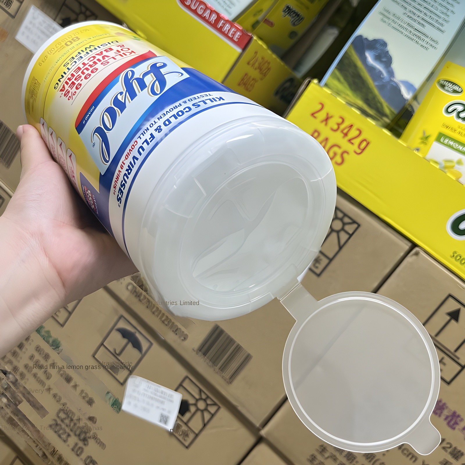 Close-up of a hand holding a Lysol container with the lid open