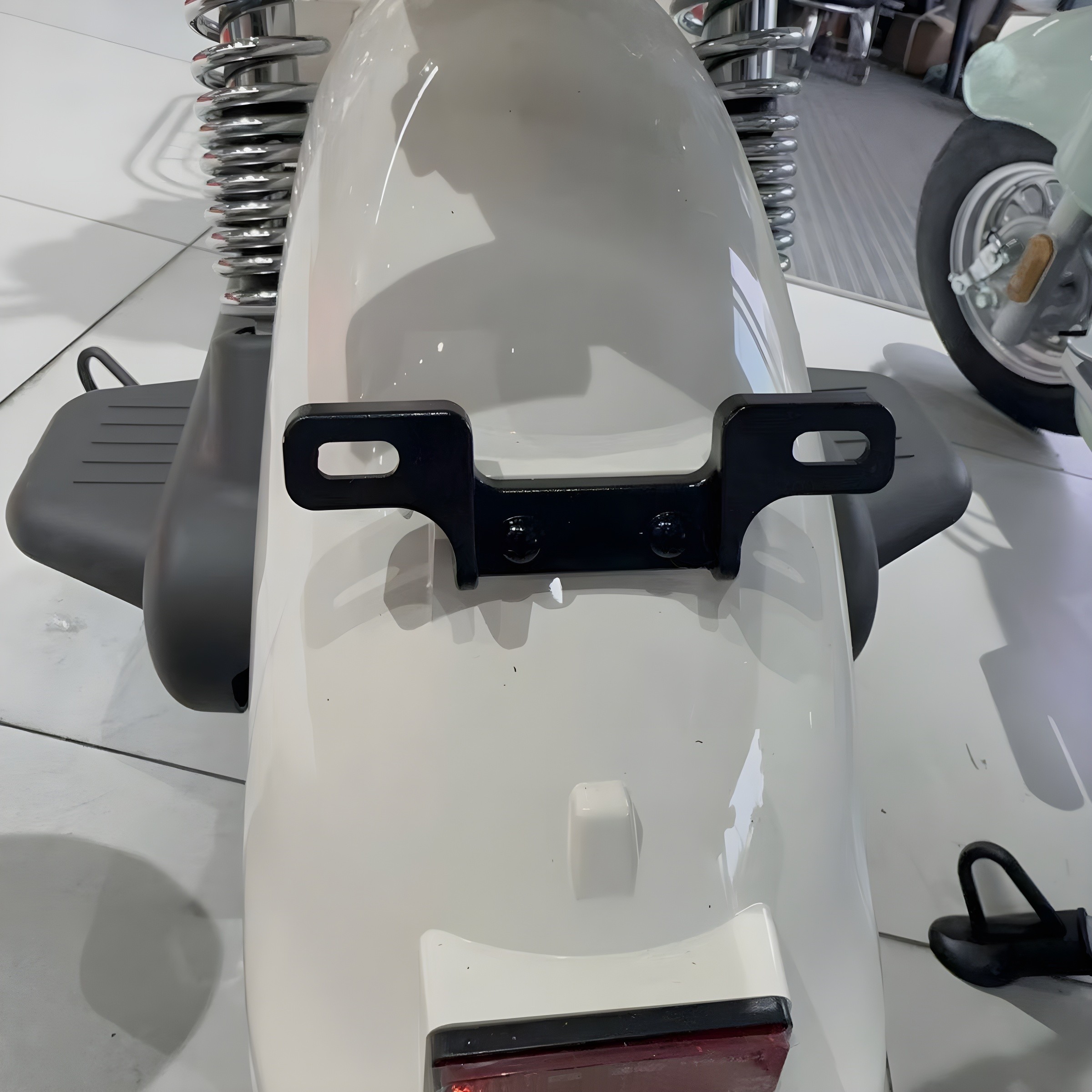 Tailplate bracket installed on white scooter