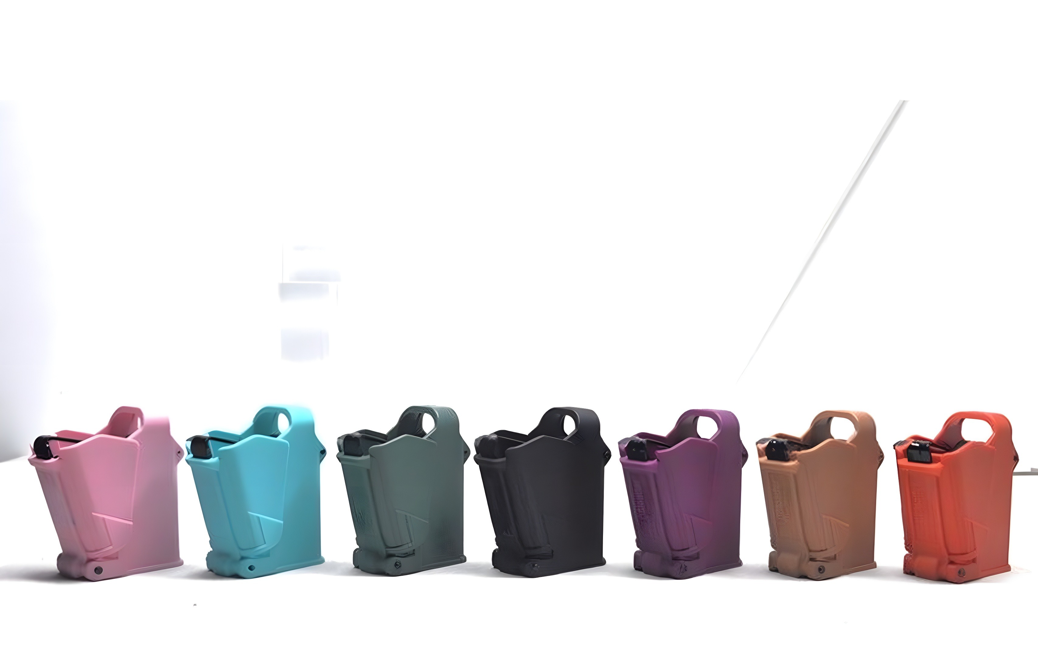 Seven SCETAC magazine pouches in gradient colors: pink, cyan, green-gray, black, purple, tan, and orange-red — arranged in a row against white background, showcasing color versatility and uniform design.