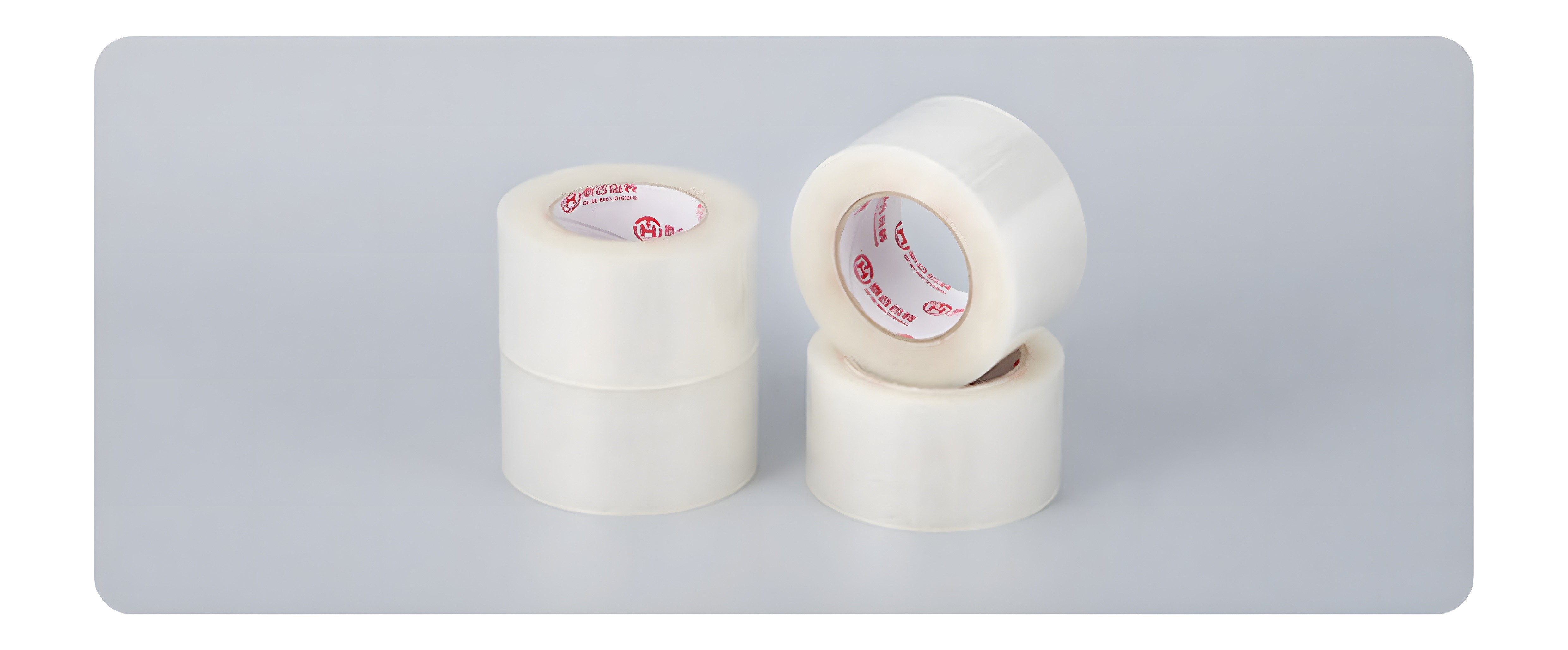 Close-up of two high-transparency BOPP tape rolls with red logo core