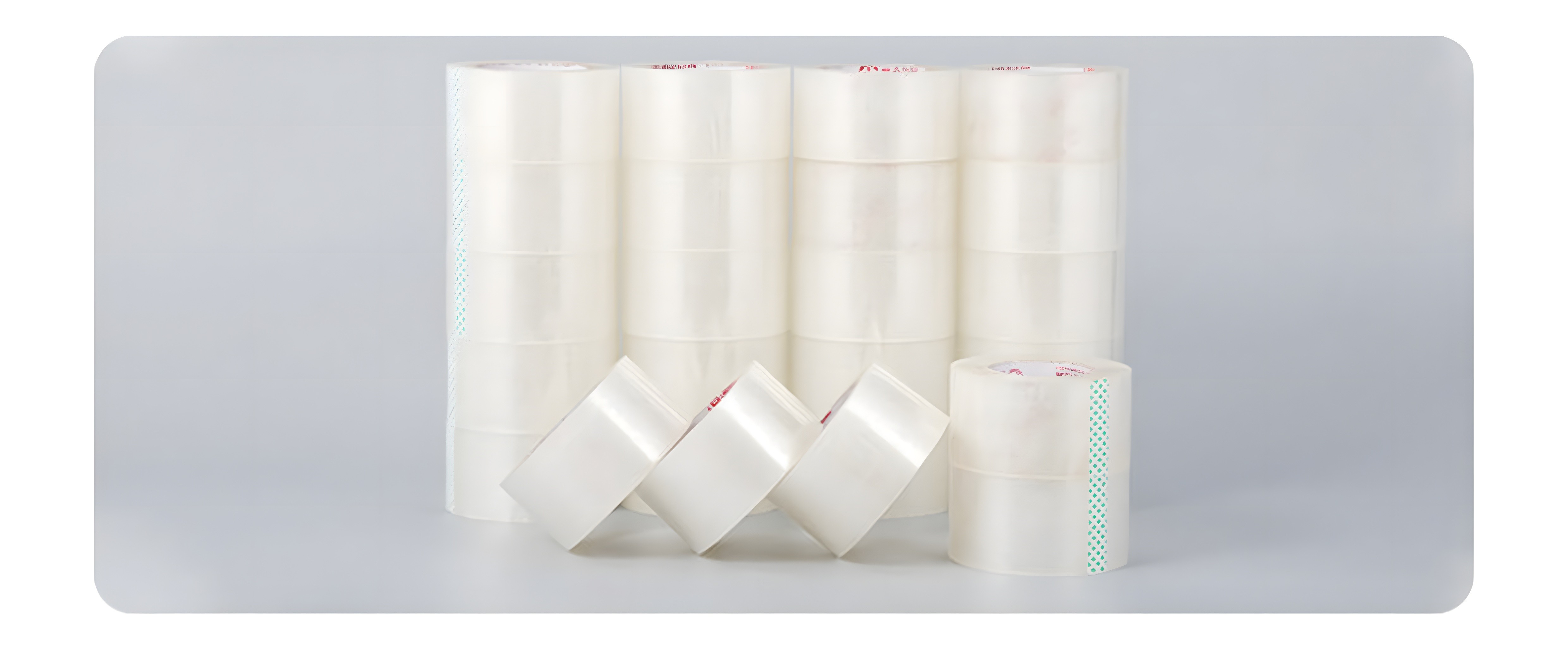 Array of 12 BOPP tape rolls arranged in stacks and fanned display, showcasing transparency and green perforated edge markers