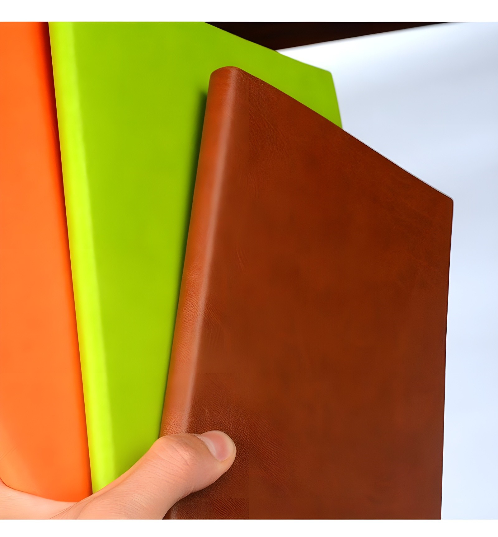 Same trio of notebooks from a slightly different angle, emphasizing the fine grain texture and ergonomic grip