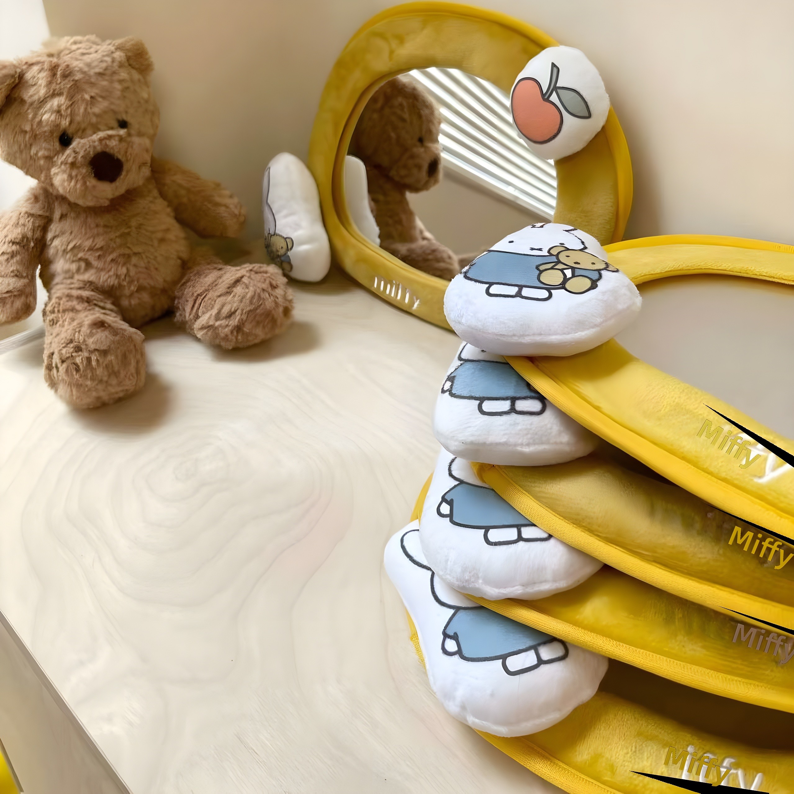 Black-and-white photo showing the mirror in use beside a teddy bear, reflecting the bear