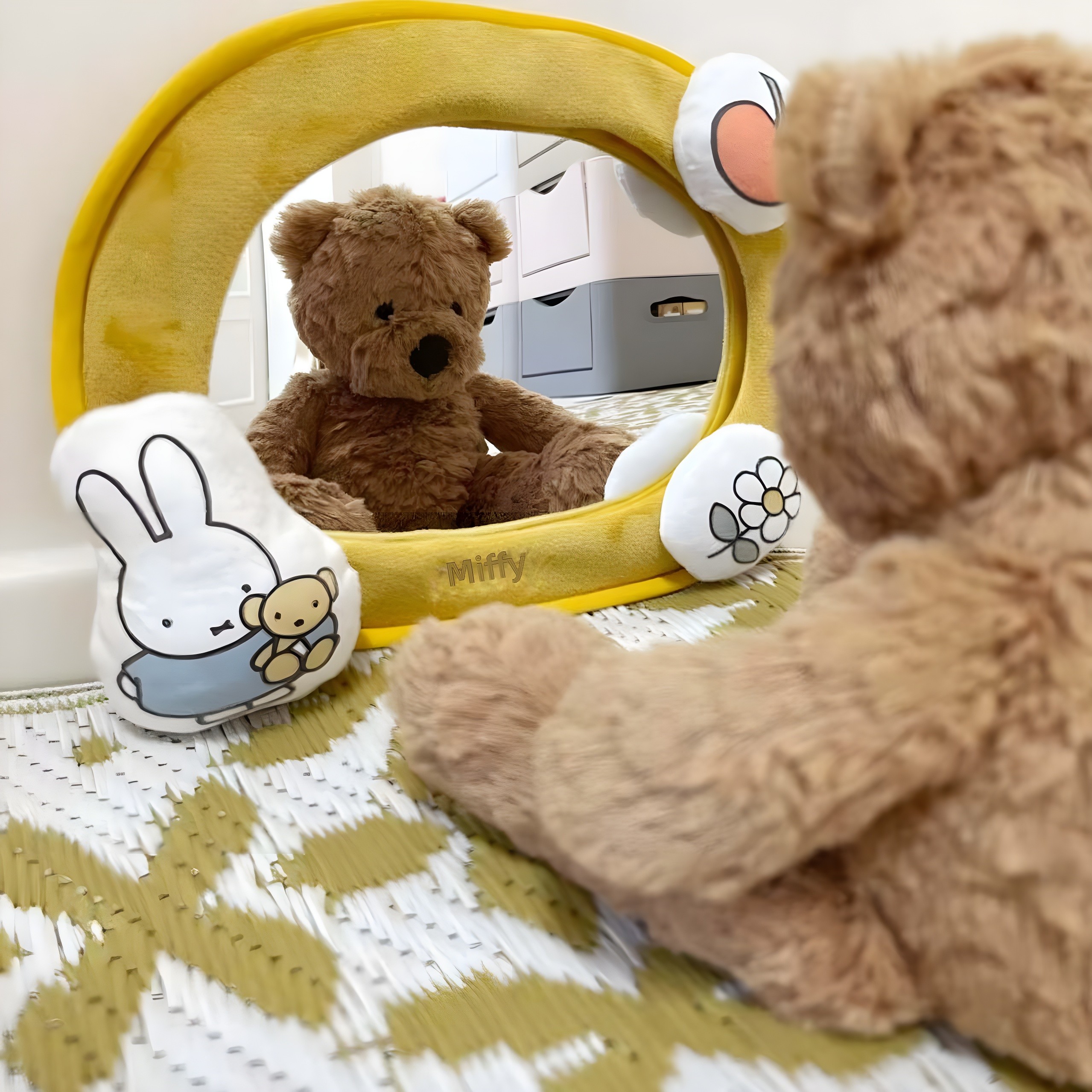 Black-and-white close-up: teddy bear looking into the Miffy mirror, reflection visible