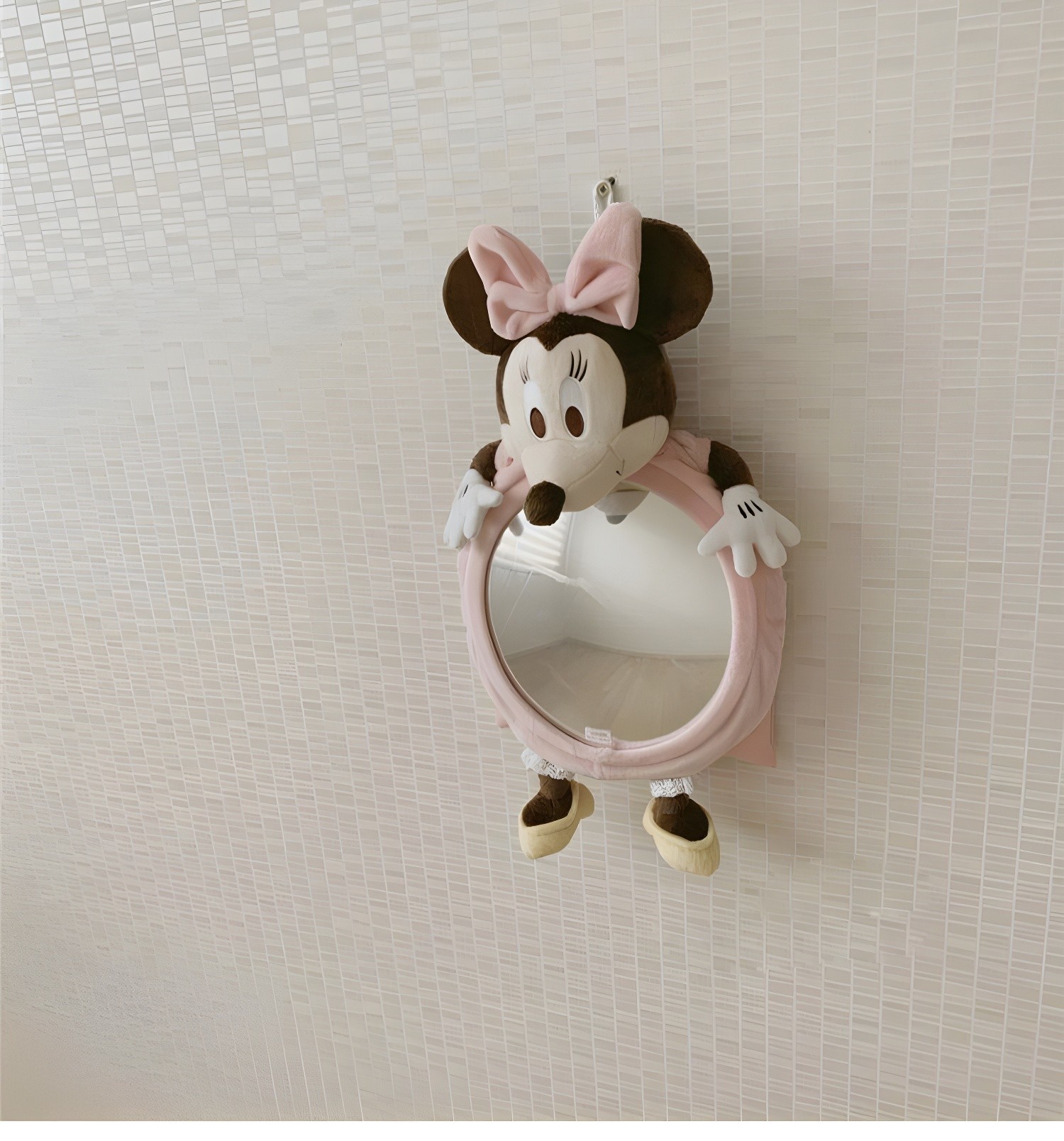 Minnie Mouse baby car mirror hanging on a tiled wall