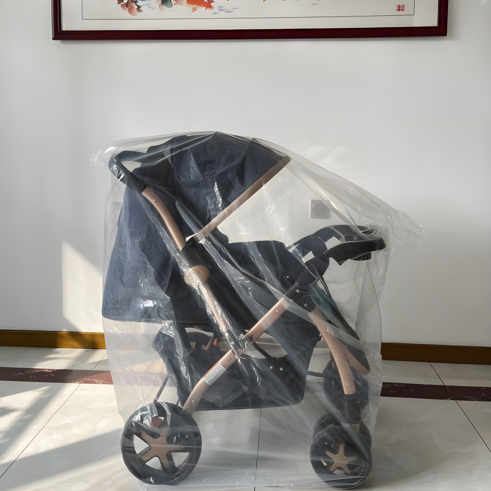 Side view of the Aurora stroller still in plastic wrap, highlighting its sleek profile and rose-gold frame