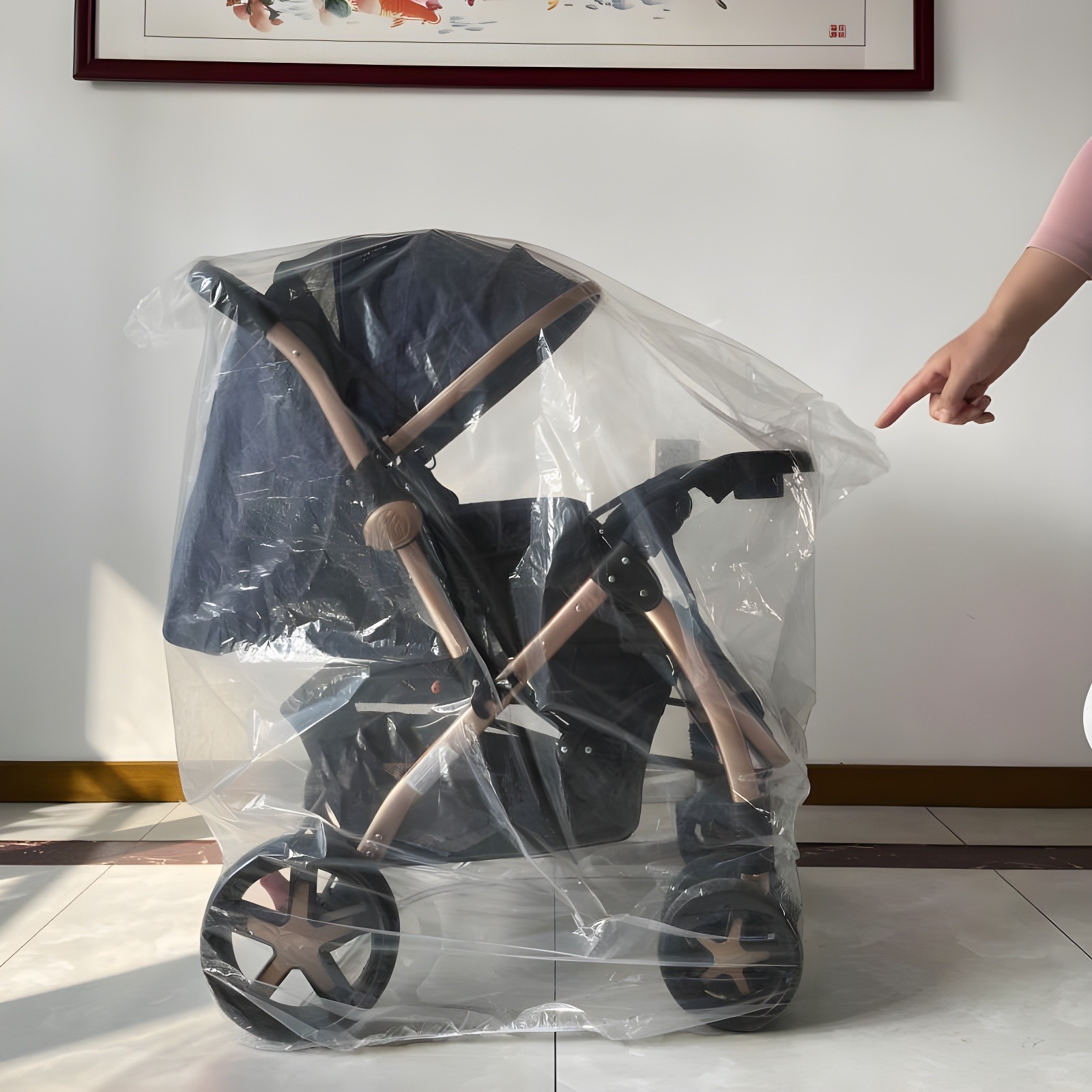 Adult hand pointing toward the stroller’s handlebar, emphasizing intuitive design and accessibility