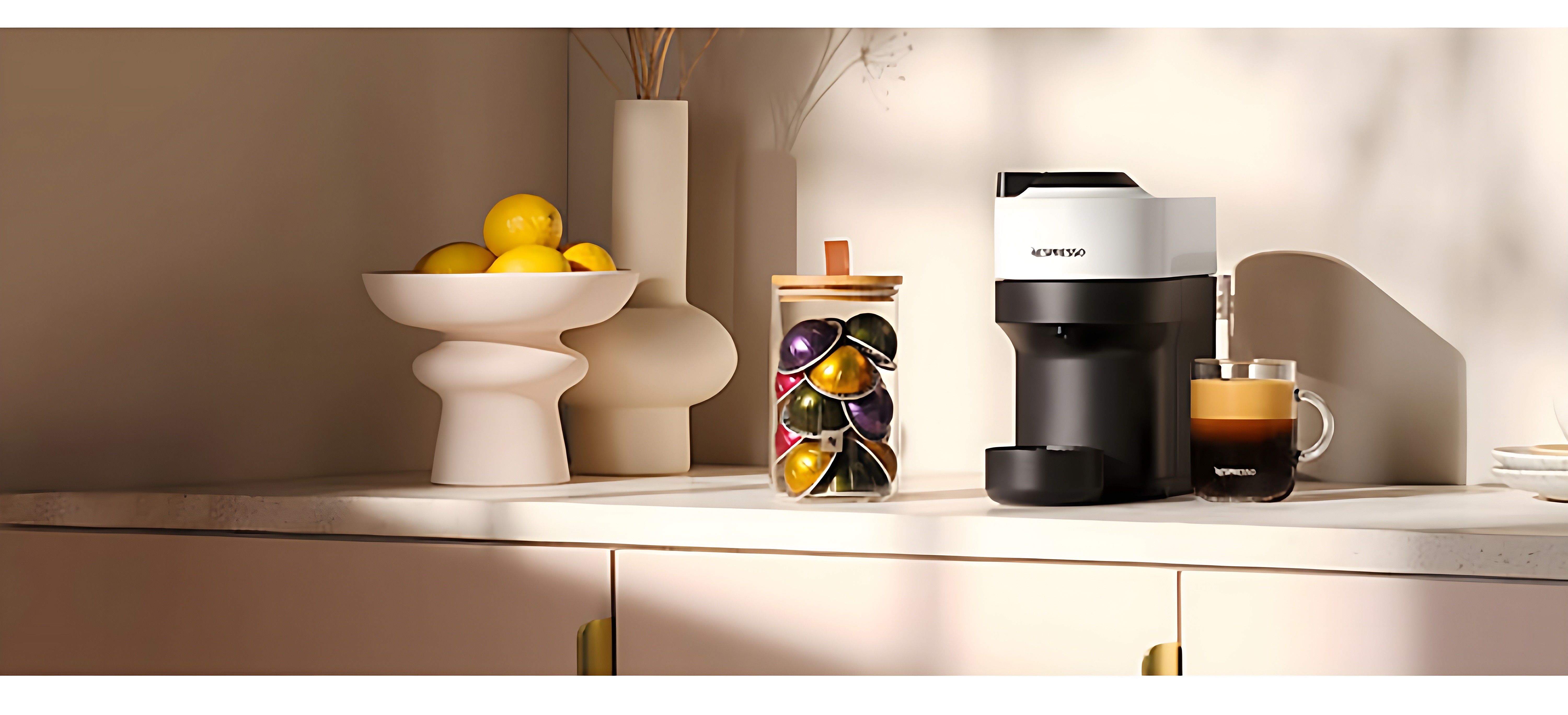 Nespresso Vertuo machine on modern kitchen counter with decorative objects and coffee capsules